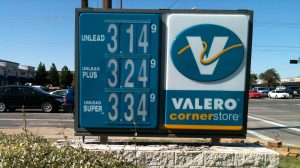 A Valero Corner Store gas station sign in Lubbock, Texas, displaying fuel prices for Unleaded at $3.14, Unleaded Plus at $3.24, and Unleaded Super at $3.34 per gallon under a clear blue sky.