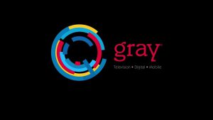 Gray Television logo featuring the brand name in a red serif font and a circular abstract icon composed of interlocking blue, yellow, and magenta segments on a solid black background.