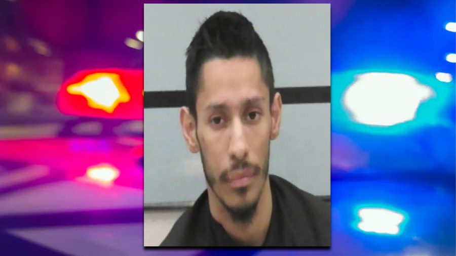 Mugshot of Jeremiah Daniel Rossette edited over a blurred background of red and blue police cruiser lights.