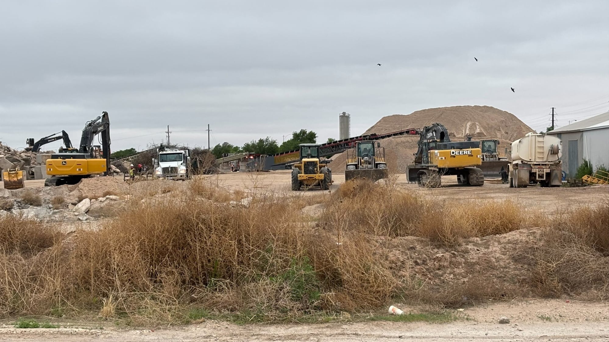 A sprawling view of heavy machinery and gravel piles at the North Avenue K plant, where the only thing more soul-crushing than the industrial accident is the actual scenery.