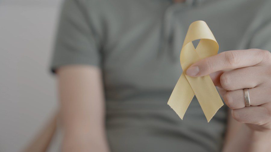 A person holding a yellow awareness ribbon, representing suicide prevention and the high volume of crisis calls in Lubbock.