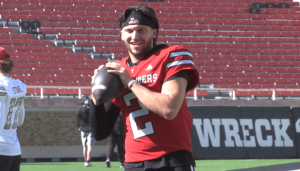 Texas Tech quarterback Brendan Sorsby smiling in a red jersey while holding a football during a practice session.