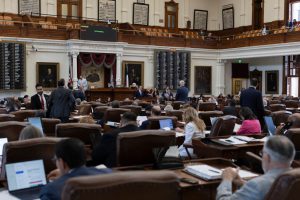 Texas lawmakers sitting at their desks in the House chamber, presumably wondering which neighborhood they can split in half next.