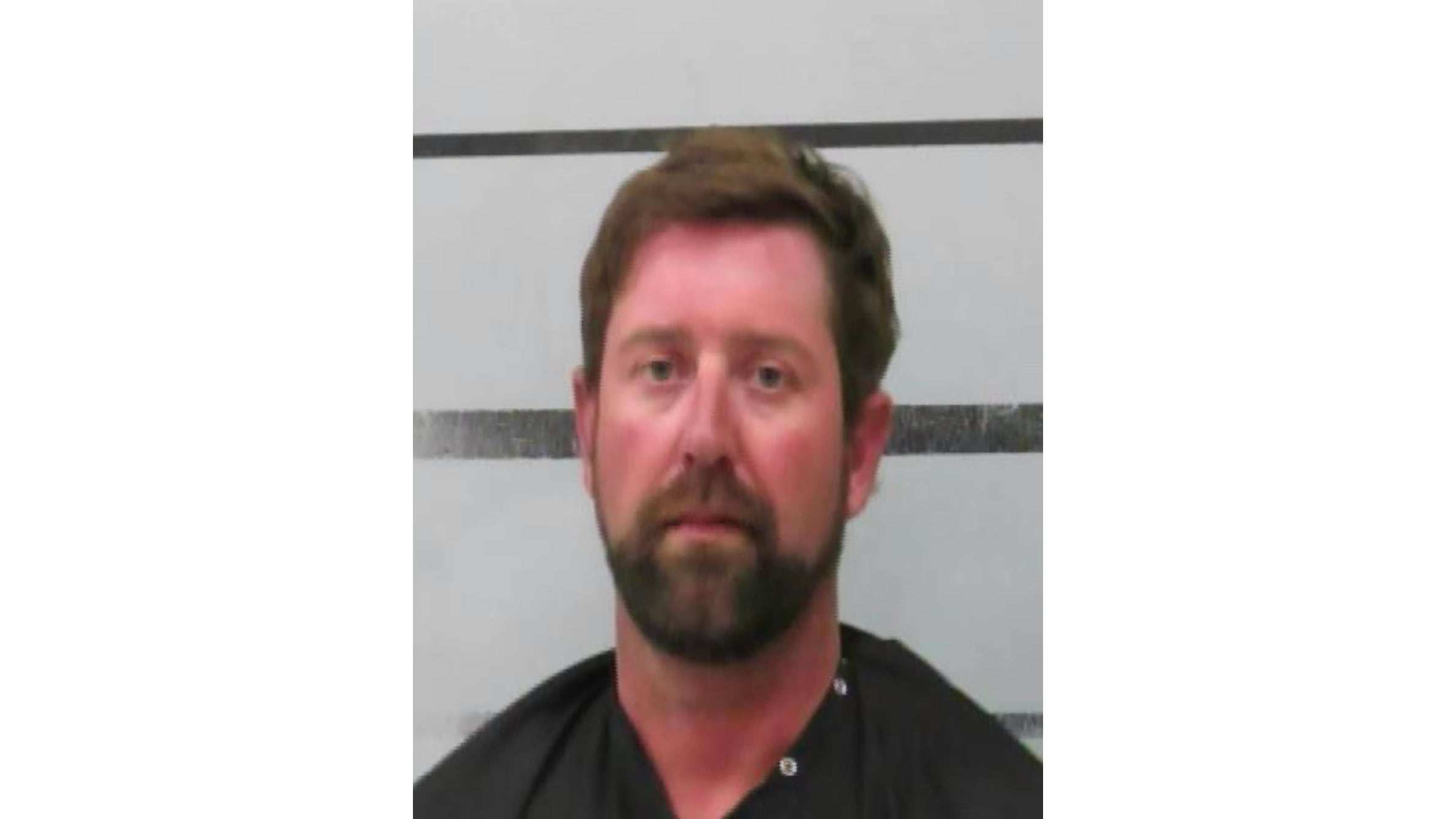 Booking mugshot of Casey Nickelson, a 39-year-old man with brown hair and a beard, standing in front of a white background with black horizontal lines.