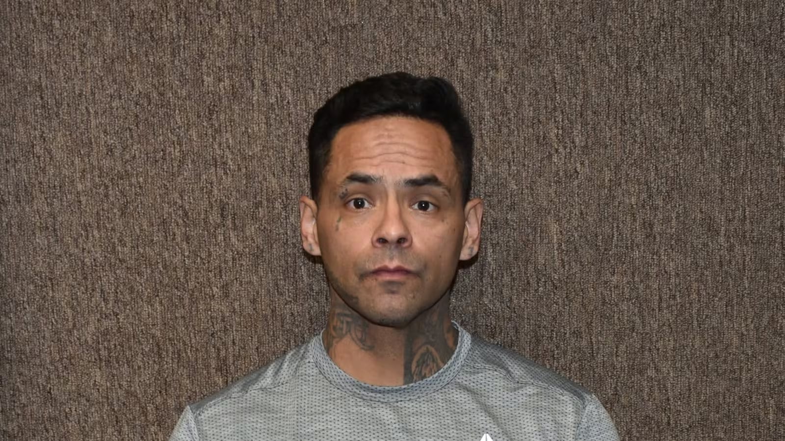 Mugshot of Andrew Robles looking directly at the camera against a textured brown background.