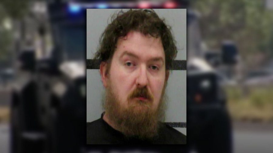 Mugshot of Derrick Karl Green featuring a disheveled beard and messy brown hair against a gray law enforcement background.