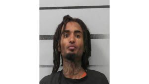 Mugshot of Isaiah Houston, a 26-year-old man with dreadlocks and a neck tattoo, following his arrest for an attempted carjacking in downtown Lubbock.