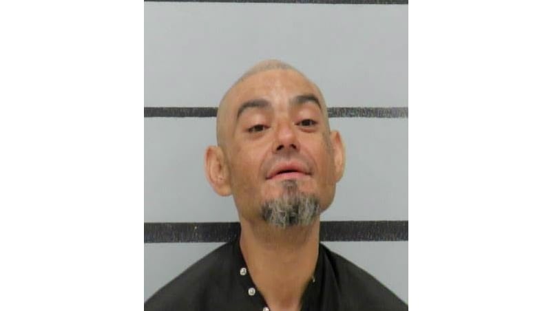 Mugshot of Jerry Smith looking upward with a graying goatee against a gray and black striped background.