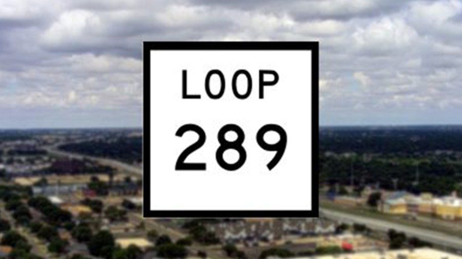 A close-up of a white square Texas highway sign with bold black lettering that reads "LOOP 289", superimposed over a blurry aerial view of Lubbock's flat landscape, roads, and residential areas under a cloudy sky.