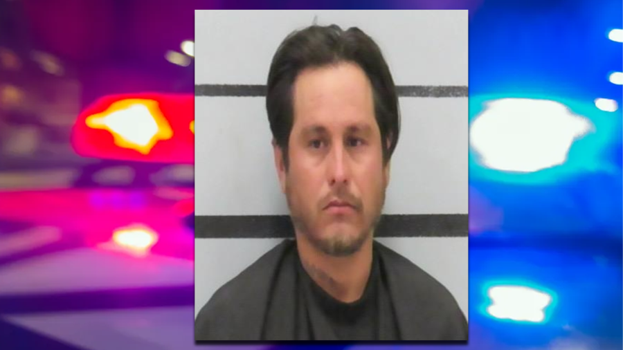 Mugshot of Pedro Marcos Hinojosa centered between a blurry graphic of red and blue police cruiser lights.