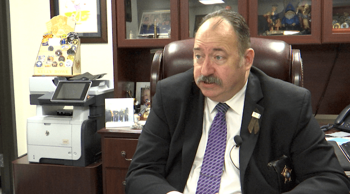 Lubbock County Sheriff Kelly Rowe sitting at his office desk looking frustrated during a public safety budget interview.
