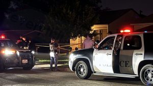 Lubbock Police vehicles parked outside a residential neighborhood at night with crime scene tape.