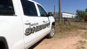 White Dawson County Sheriff pickup truck parked on a dirt road in West Texas.