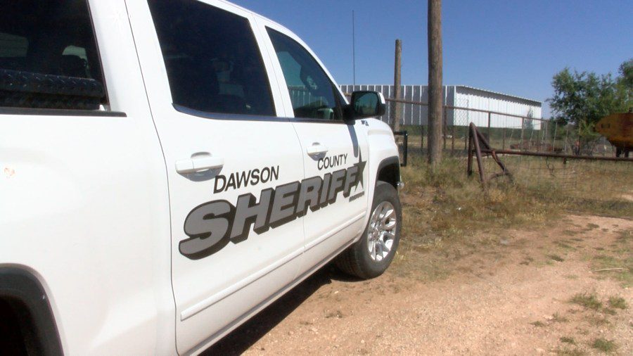 White Dawson County Sheriff pickup truck parked on a dirt road in West Texas.